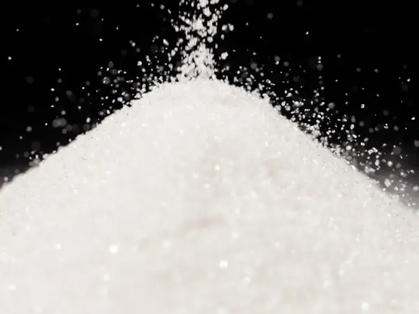 Biały, drobny proszek, przypominający cukier lub sorbitol, sypie się na stożek.